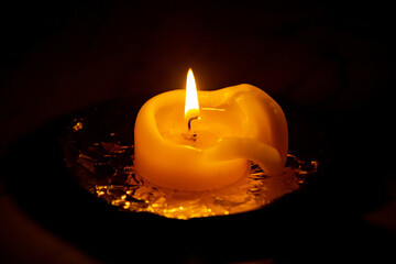 Burning candle isolated in selective focus