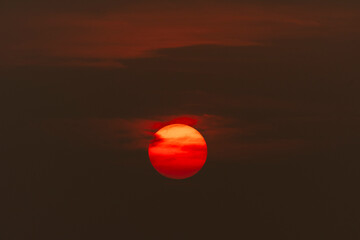 Evening sky time with sun and orange clouds in sunset sky background.Heat wave hot sun, climate change and global warming concept.