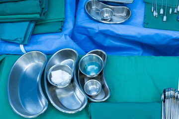 Surgical clamps and medical equipment on green surgical tray inside operating room.Sterile surgical...