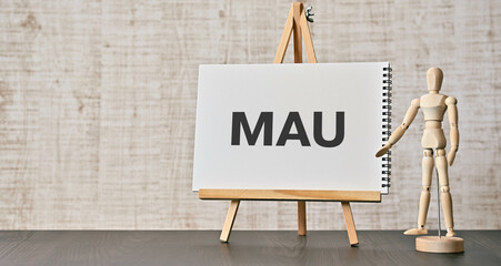 There is notebook with the word MAU. It is an abbreviation for Monthly Active Users as eye-catching...