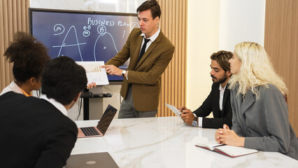 Presentation in ornamented meeting room with business professionals attending to project...