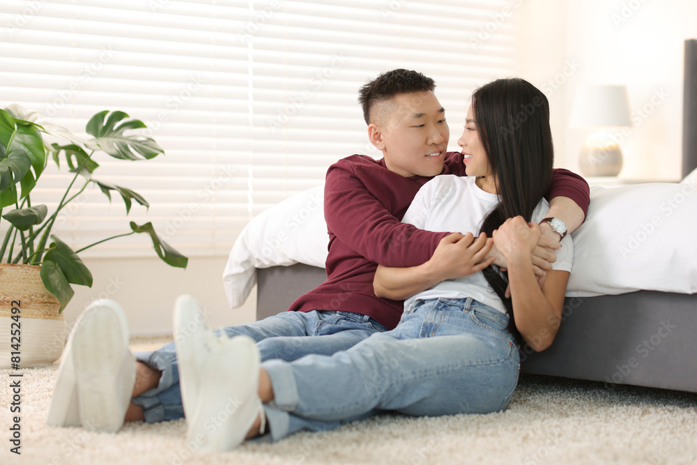 Wall mural Lovely young couple on floor at home