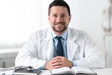 Obraz premium Portrait of smiling doctor at table in clinic