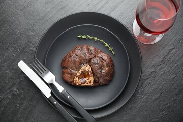 Tasty grilled beef meat served on black table, flat lay