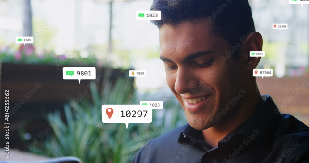 Aufkleber image of social media icons floating over caucasian man smiling while using smartwatch