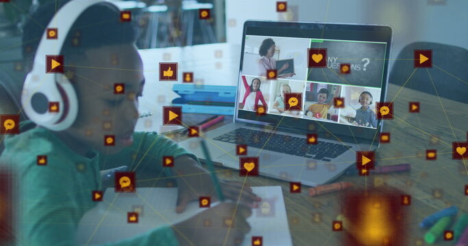 Image of digital icons over african american boy doing homework looking at laptop at home