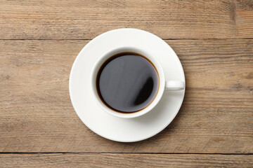 Cup of aromatic coffee on wooden table, top view