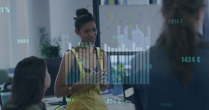 Image of statistical data processing against biracial woman talking to her colleagues at office