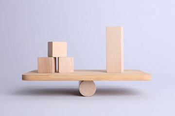 Equality concept. Seesaw scale with wooden blocks on light background