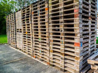 Large Stack Of Wood Pallets Outside In A Parking Lot