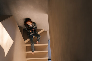 High-angle view portrait of sad pensive female in casual clothes with apathy expression sitting...