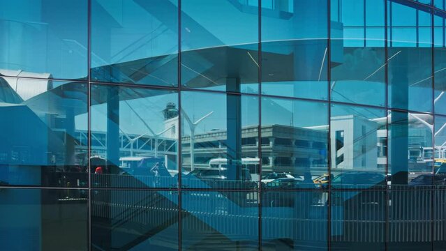 Airport traffic reflecting in blue glass wall of a modern building, abstract business transportation background concept.