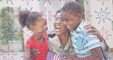 Image of fireworks over happy african american soldier mother hugging kids