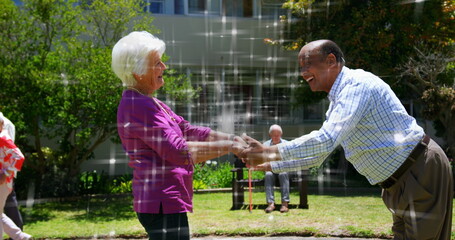 Image of light spots over diverse senior friends dancing