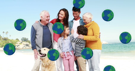 Image of globe icons over caucasian family at beach