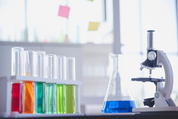 Science laboratory chemistry test science lab with microscope, glass tubes, chemical beaker white table scientific background. Colorful Liquid biology laboratory chemical fluid scientist experiment