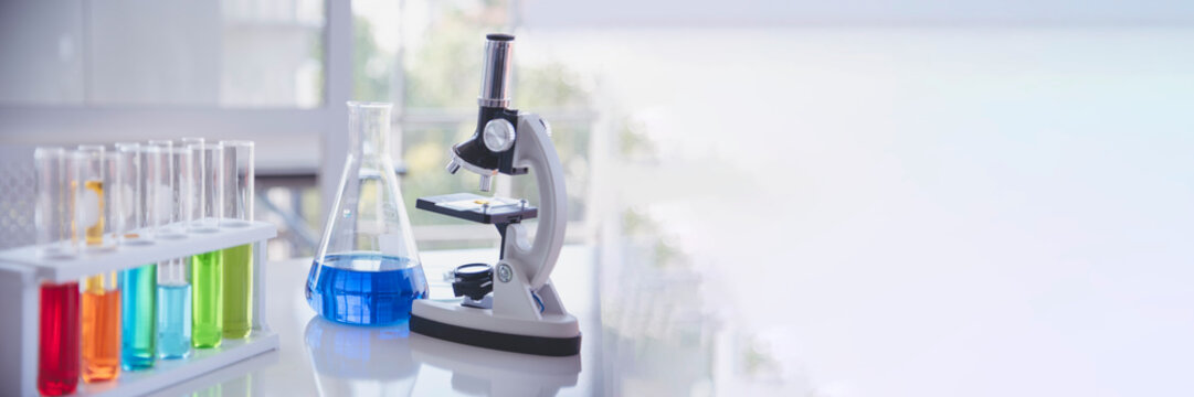 Banner Science laboratory chemistry test science lab with microscope glass tubes chemical beaker scientific background. Colorful Liquid biology laboratory fluid scientist experiment with copy space
