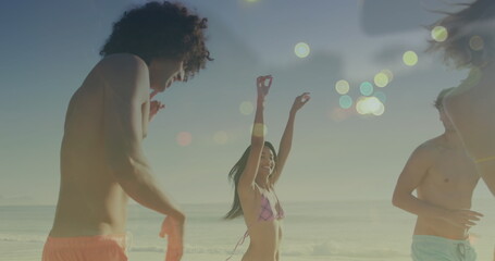 Image of light spots over happy diverse friends dancing at beach - Powered by Adobe