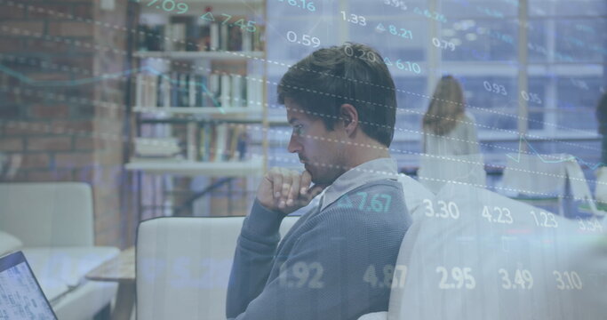 Image of stock market data processing over thoughtful caucasian man using laptop at office
