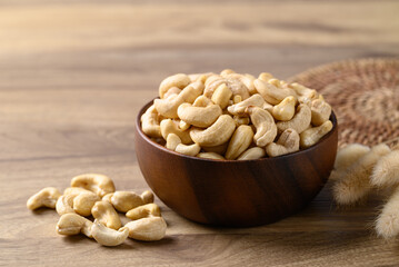 Raw cashew nuts in bowl on wooden background, Food ingredient