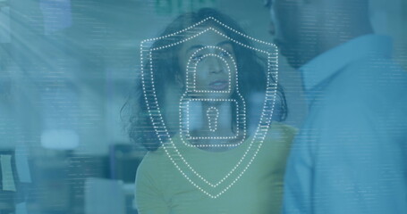 Image of dots forming padlock in shield over diverse coworkers discussing in office