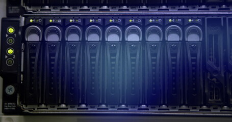 Rows of hard drives glowing in blue inside server rack