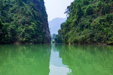 Obraz premium River in the mountains. Calm green river between high rock hills in Ha Giang, Vietnam. Beautiful landscape of Ha Giang, North Vietnam. Canyon river.