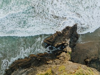Waves crashing over rocks. Anawhata, Auckland, New Zealand.