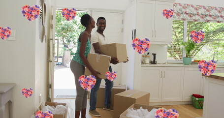 Image of heart icons with flowers over african american couple moving house
