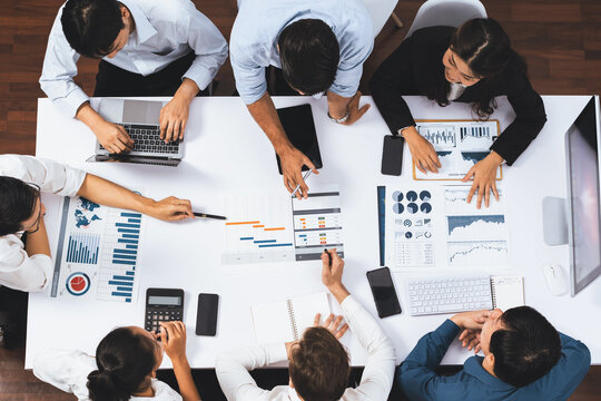 Top view project manager communicate and collaborate with team using project management software, tracking progress of project task and making schedule plan at meeting table. Prudent