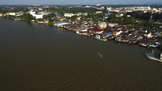 Drone shot of a small boat driving in front of the Surat Thani, sunny Thailand