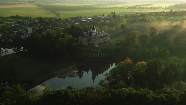 adun Castle during sunrise surrounded by morning mist covering the vast park.