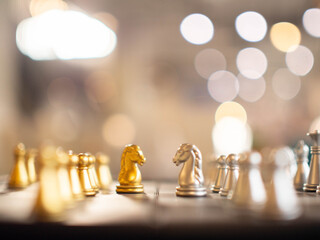 Chess horse face to face conflict competition strategy game piece object game copy space bokeh background knight challenge board chessboard success golden silver color war business education marketing