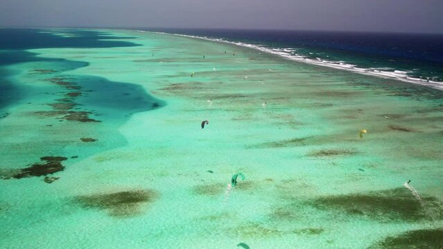 Kite surfers on turquoise waters at los roques barrier reef, vibrant and scenic, aerial view
