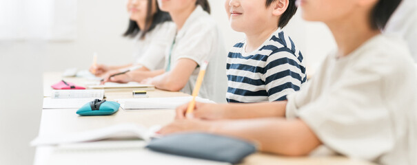 塾・学校で笑顔で授業を受ける小学生の男の子・男女
