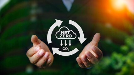 Net zero, carbon neutrality concept. Net zero icon at on hand green blur background. Green Energy...