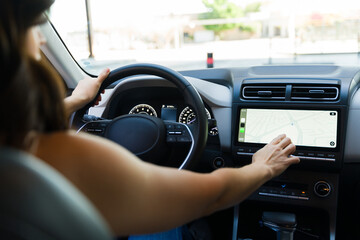 Determined woman navigates with a touch screen gps in a modern car