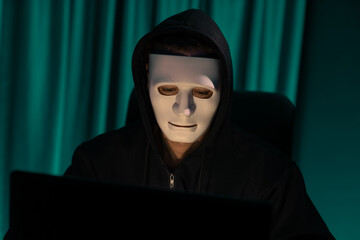 White criminal anonymous mask installing coding password encryption by programming hack, trying to...