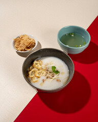 Hong Kong cuisine. Porridge with dumplings, chicken and spring onions.