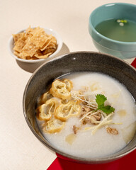 Hong Kong cuisine. Porridge with dumplings, chicken and spring onions.