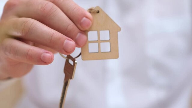 Man real estate agent or property owner giving house key to customer after singing contract close up. Home loan, mortgage, investment, rent, real estate concept. Selective focus