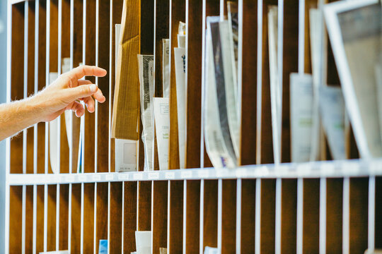 Hand reaches into wooden mail organizer, selecting