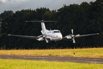 Low pass of a small plane, King Air, flying over the runway, airplane takeoff