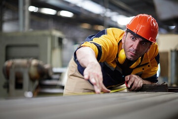 worker or technician using tape measure and measuring the length of the machine in the factory