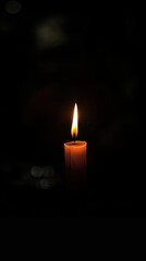 A powerful image of a single candle or small light in the foreground