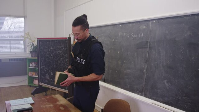 Wide shot of cop in classroom reading to students