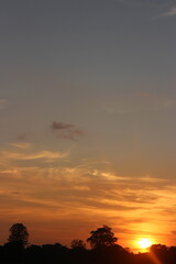 Natural Sunset Sunrise Over Field Or Meadow. Bright Dramatic Sky And Dark Ground. Countryside Landscape Under Scenic Colorful Sky At Sunset Dawn Sunrise. Sun Over Skyline, Horizon. Warm Colours.