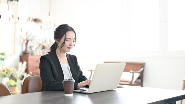 オフィスでパソコンを使いタイピングをする女性の横顔のクローズアップの動画