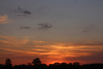 Sunset Sky Clouds in the evening with Red, Orange, Yellow and purple sunlight on Golden hour after sundown, Romantic sky in summer on Dusk Twilight