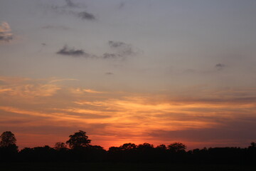 Sunset Sky Clouds in the evening with Red, Orange, Yellow and purple sunlight on Golden hour after sundown, Romantic sky in summer on Dusk Twilight